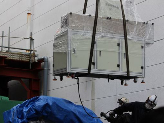 写真：クレーンで生産設備を荷上げのイメージ